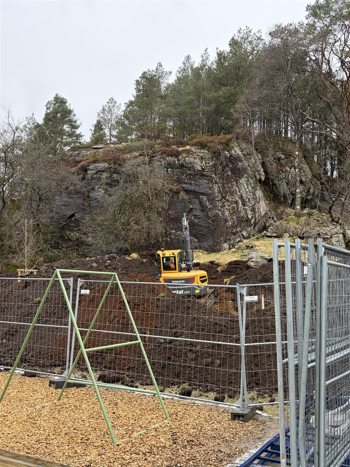gravemaskin, byggegjerder og en del jord, klarlegger til å bore ettter bergvarme - Klikk for stort bilde
